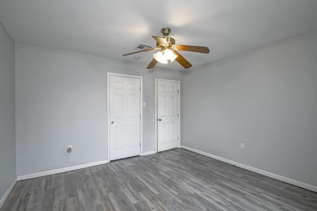 unfurnished bedroom with ceiling fan and dark hardwood / wood-style flooring