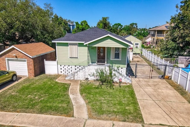 bungalow with a front yard, a garage, and an outdoor structure