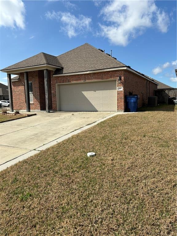 view of front of house with a front yard, cooling unit, and a garage