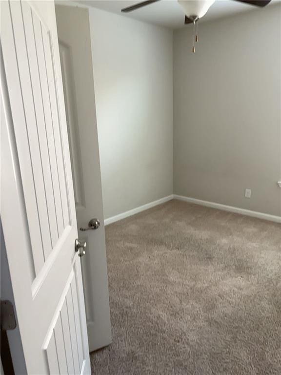 carpeted empty room featuring ceiling fan