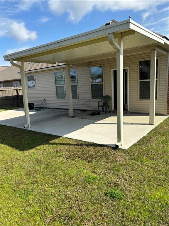 rear view of property featuring a lawn and a patio area