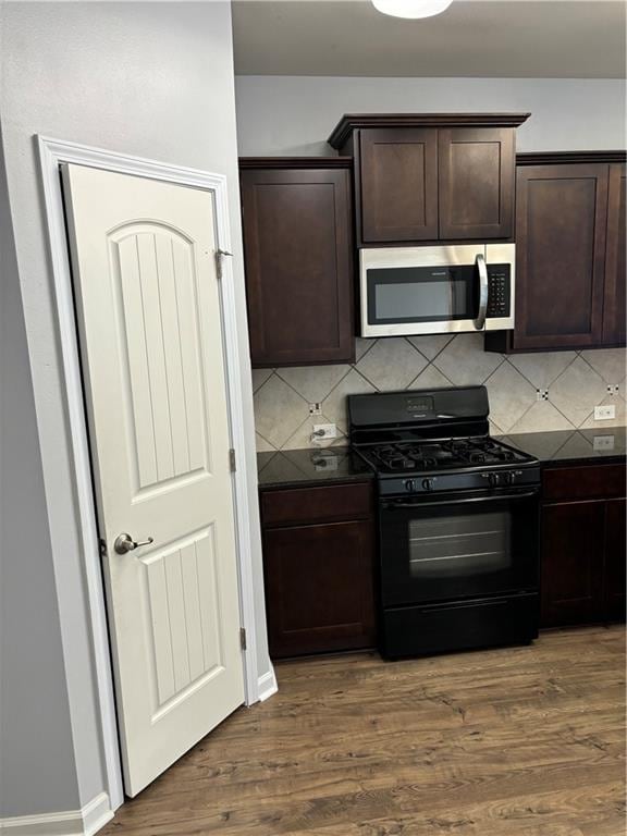 kitchen with dark hardwood / wood-style floors, dark brown cabinets, decorative backsplash, and black gas range oven