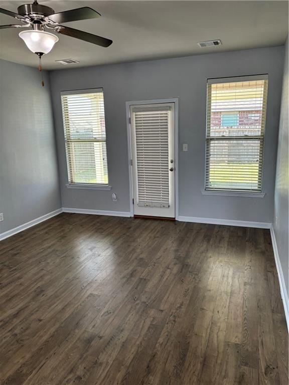 empty room with ceiling fan and dark wood-type flooring