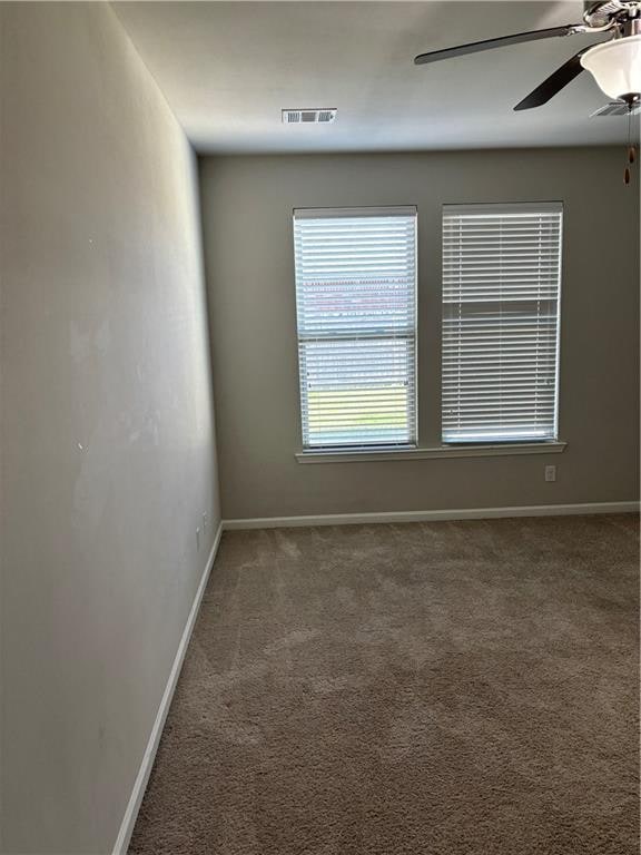 carpeted spare room with ceiling fan