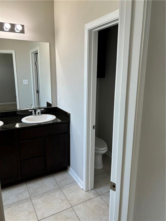 bathroom featuring tile patterned floors, vanity, and toilet