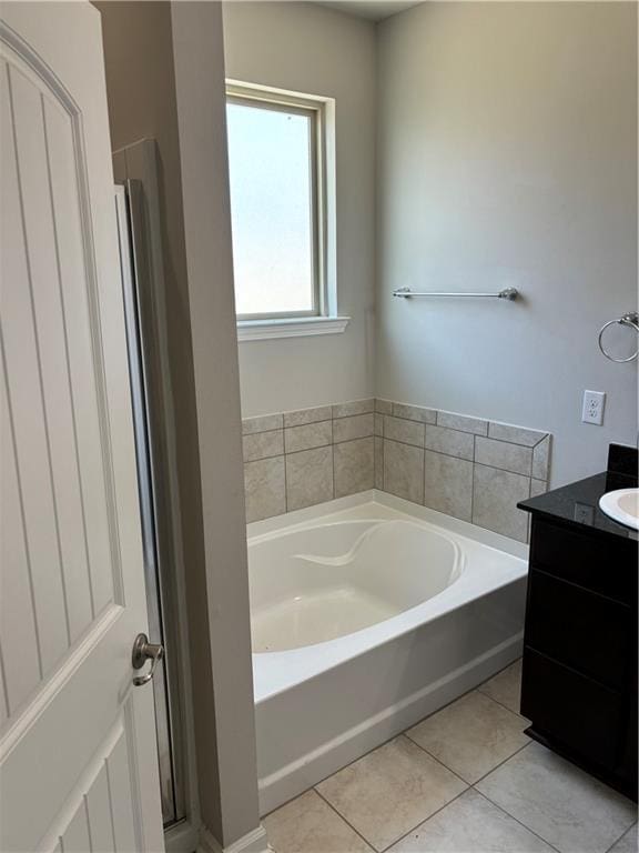 bathroom featuring tile patterned floors, vanity, and a bathing tub