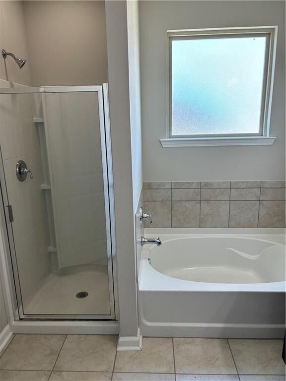 bathroom with separate shower and tub and tile patterned floors