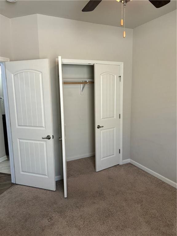 unfurnished bedroom featuring ceiling fan, a closet, and carpet