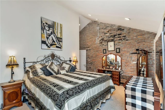 carpeted bedroom with high vaulted ceiling and brick wall