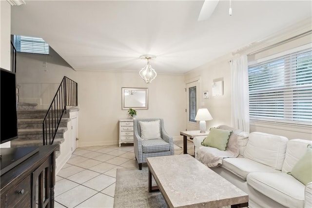 tiled living room with ceiling fan with notable chandelier