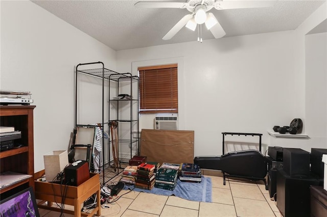 interior space featuring ceiling fan, cooling unit, a textured ceiling, and light tile patterned floors