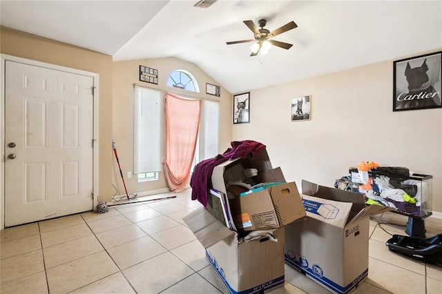 interior space with vaulted ceiling, plenty of natural light, light tile patterned flooring, and ceiling fan