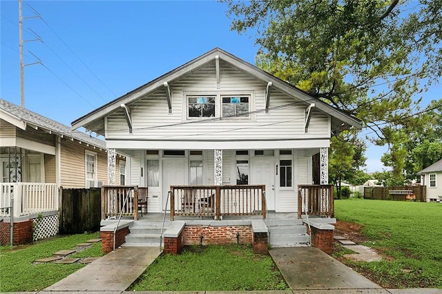 bungalow-style home with covered porch and a front lawn