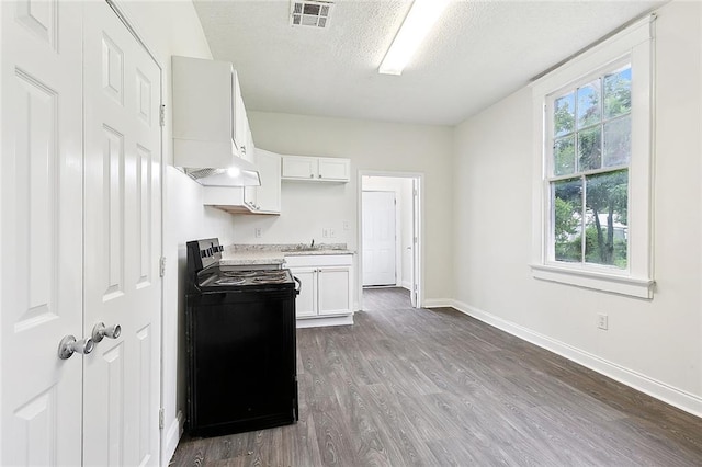 kitchen featuring custom range hood, black range with electric stovetop, dark hardwood / wood-style flooring, white cabinetry, and a textured ceiling