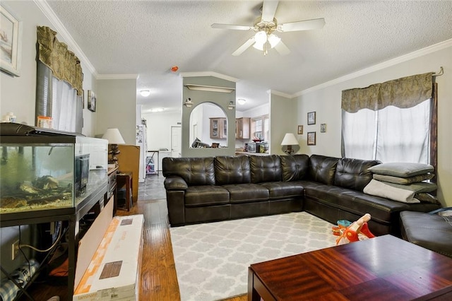 living room featuring ornamental molding, ceiling fan, dark hardwood / wood-style floors, and a textured ceiling