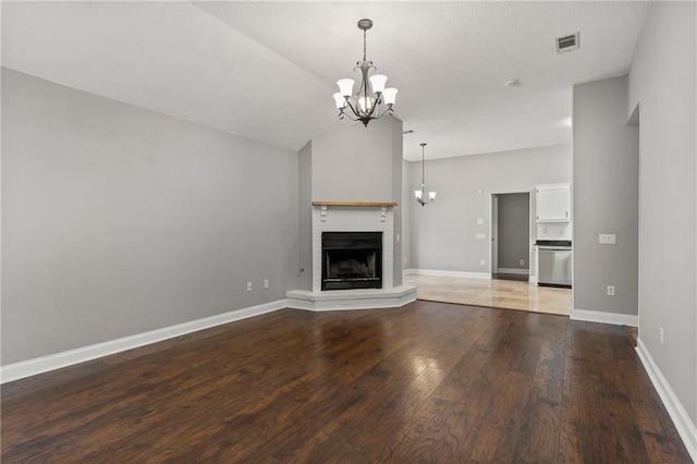 unfurnished living room with vaulted ceiling, wood-type flooring, and a chandelier