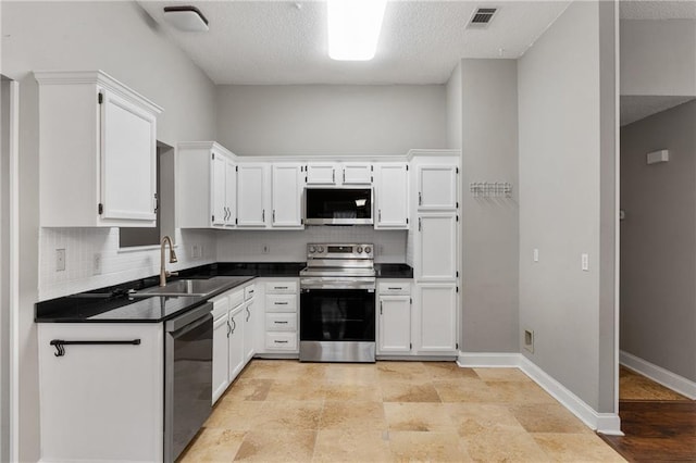 kitchen with sink, appliances with stainless steel finishes, white cabinetry, tasteful backsplash, and a textured ceiling