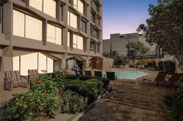 pool at dusk with a patio