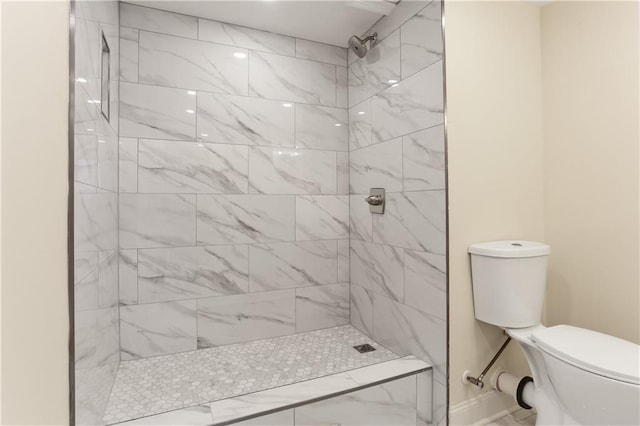 bathroom with toilet and a tile shower