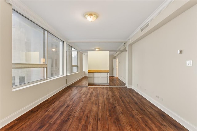 unfurnished room with ornamental molding and dark hardwood / wood-style flooring