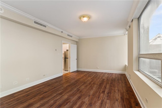 empty room with crown molding and wood-type flooring