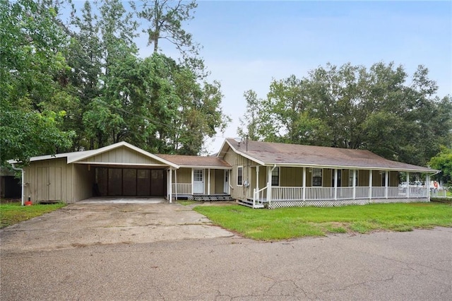 ranch-style home featuring a front yard, a garage, and a porch