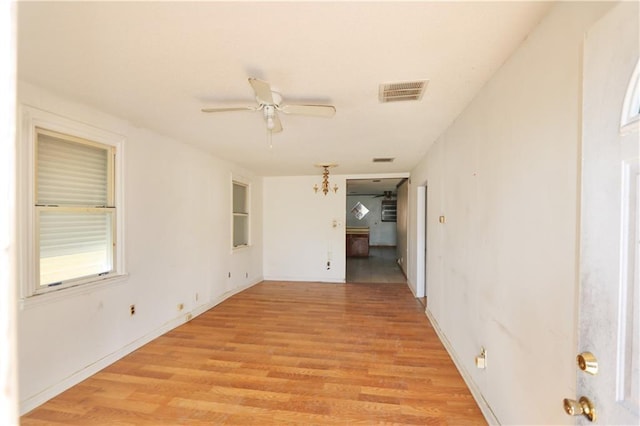 empty room with ceiling fan and light wood-type flooring