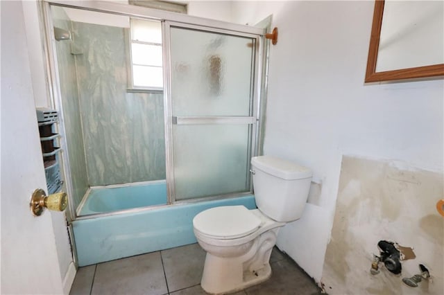 bathroom with enclosed tub / shower combo, tile patterned floors, and toilet