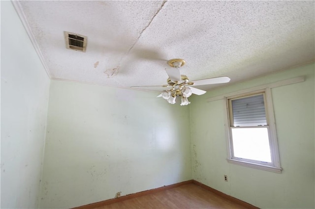 spare room with ceiling fan, light hardwood / wood-style floors, and a textured ceiling