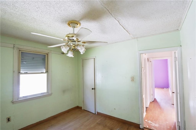 spare room featuring ceiling fan, a textured ceiling, and light wood-type flooring