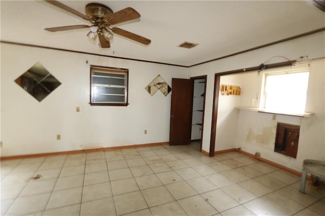 tiled spare room with ornamental molding and ceiling fan