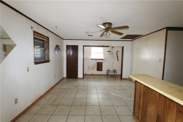 tiled foyer with crown molding and ceiling fan