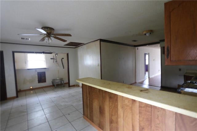 kitchen featuring kitchen peninsula, light tile patterned floors, and ceiling fan