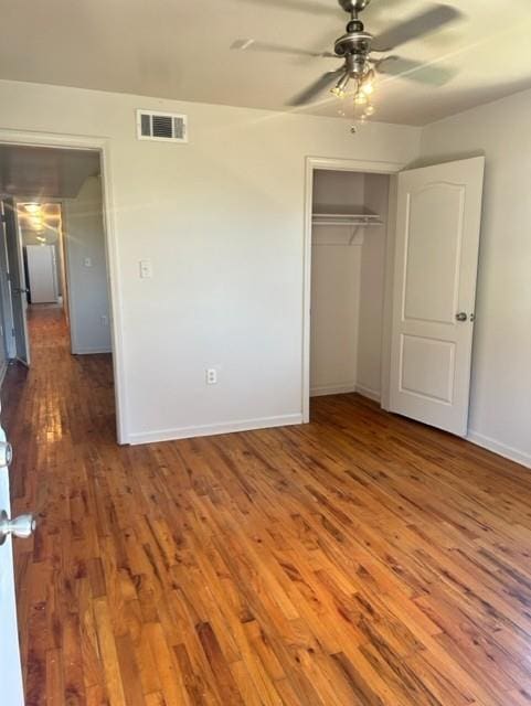 unfurnished bedroom featuring hardwood / wood-style floors, a closet, and ceiling fan