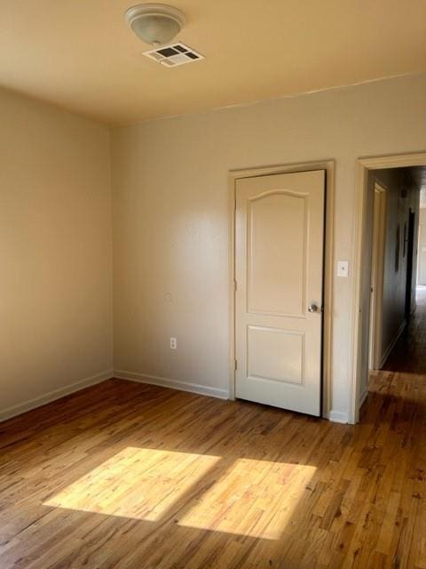 unfurnished room with hardwood / wood-style floors