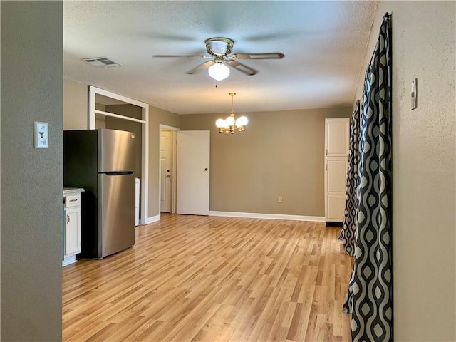 interior space with ceiling fan with notable chandelier, light hardwood / wood-style floors, and a textured ceiling