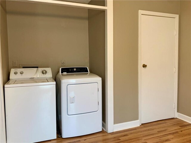 laundry room featuring light hardwood / wood-style flooring and washing machine and dryer