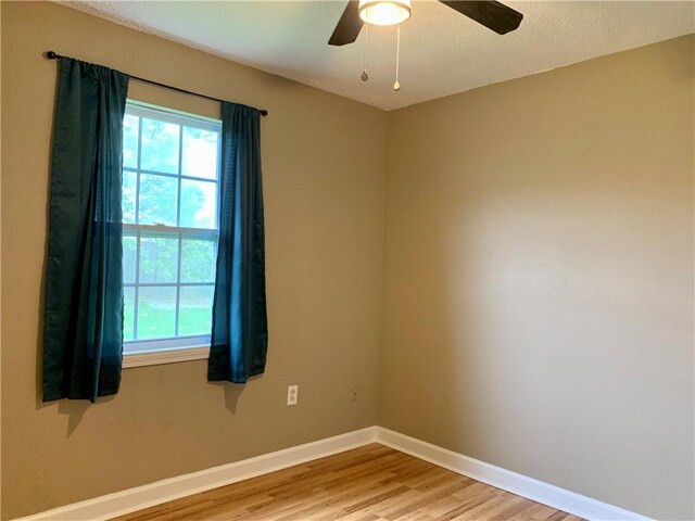 spare room featuring a textured ceiling, ceiling fan, and light wood-type flooring