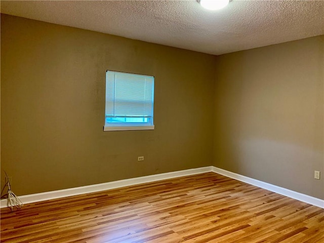 empty room featuring a textured ceiling and hardwood / wood-style flooring