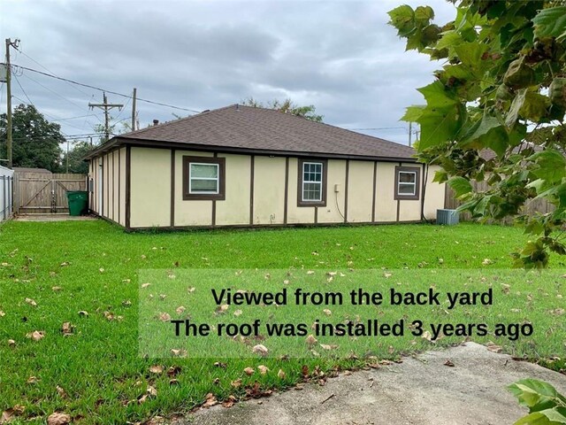 rear view of property featuring a lawn