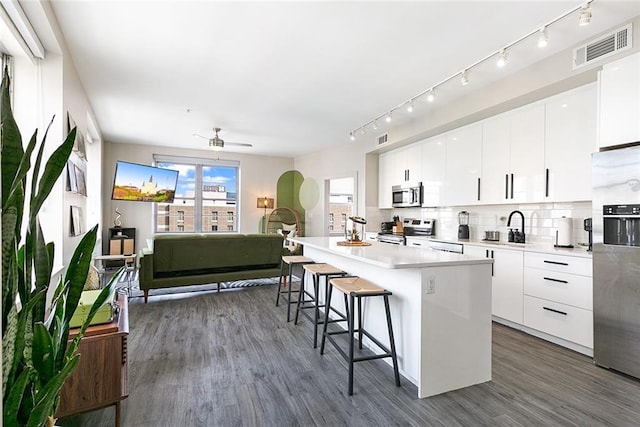 1111 Tulane Ave Unit 721, New Orleans, LA 70112 - kitchen featuring stainless steel appliances, modern cabinets, a center island, visible vents, and a kitchen breakfast bar