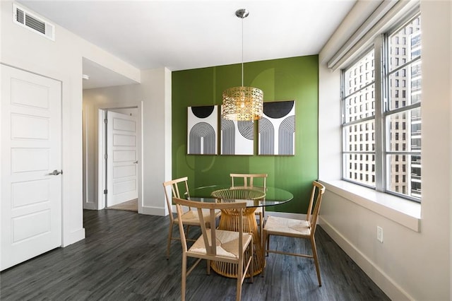 dining room featuring a wealth of natural light, dark wood-type flooring, and a notable chandelier