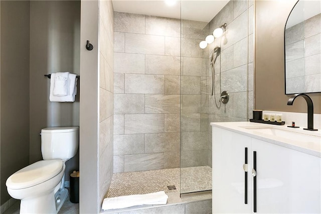 bathroom with vanity, toilet, and a tile shower