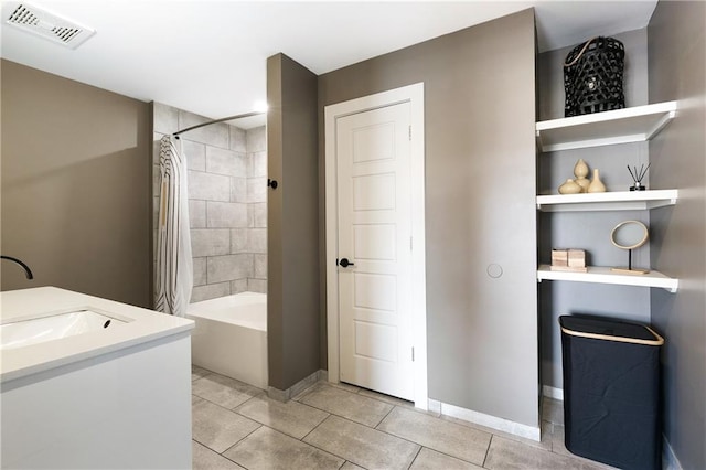 bathroom featuring tile patterned flooring, shower / bath combo with shower curtain, and vanity