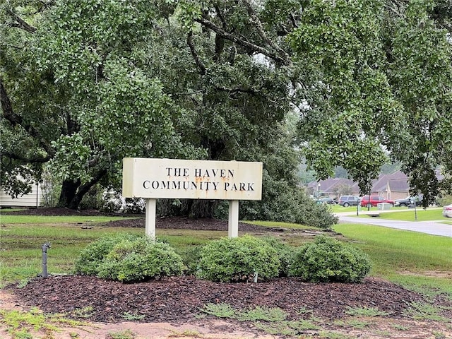 community / neighborhood sign with a yard