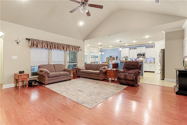 living room featuring ornamental molding, ceiling fan, light hardwood / wood-style flooring, and high vaulted ceiling