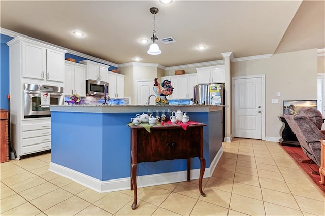 kitchen with white cabinets, light tile patterned floors, a center island with sink, appliances with stainless steel finishes, and a kitchen breakfast bar