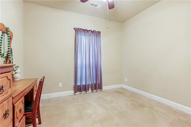 unfurnished office with ceiling fan and light carpet