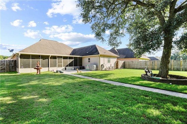 rear view of property featuring a sunroom and a yard