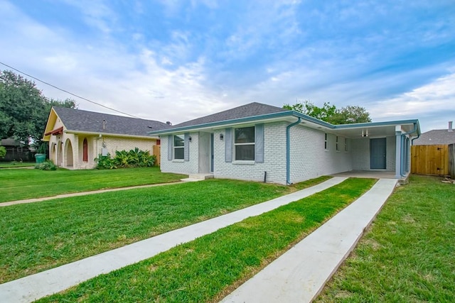 ranch-style home featuring a front lawn and a carport